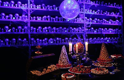 A large orb decorated with a projection of the prophecy Harry sees in the film hung in front of smaller orbs and above an elaborately decorated dessert buffet.