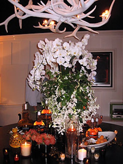 An arrangment of orchids, natural elements such as apricots and amber, and Navan bottles adorned a large wooden table in the center of the main space.