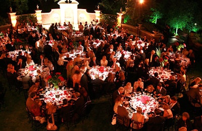 Guests dined alfresco at elegant black-and-white-dressed tables.