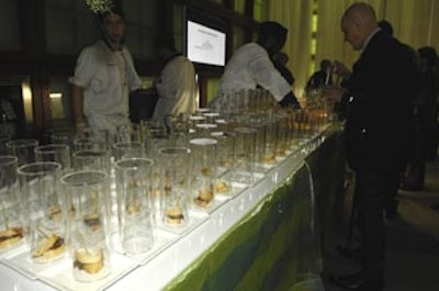 Eatertainment served club sandwiches on small plates with burning bamboo skewers smothered beneath clear plastic tubes.