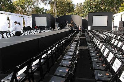 Simple white chairs popped against the black outdoor carpeting and black backdrop.