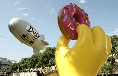 A Duff Beer blimp hovered over the yellow carpet, which was decorated with giant installations of Homer's hand holding a doughnut.