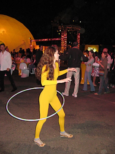 Performers dressed in yellow spandex body suits hula-hooped by the entrance to the party.