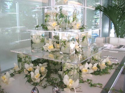 Three-layers of acrylic shelving were accented with wild white flowers and green vines for the all-white-chocolate sushi display from Ginger Island.