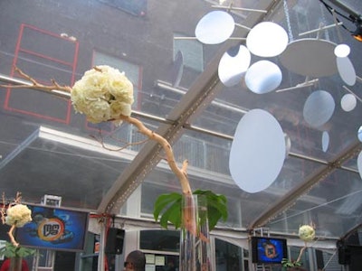 A modern linear hanging mobile specially designed for the event by 3 Design was placed overhead under the clear top tent.