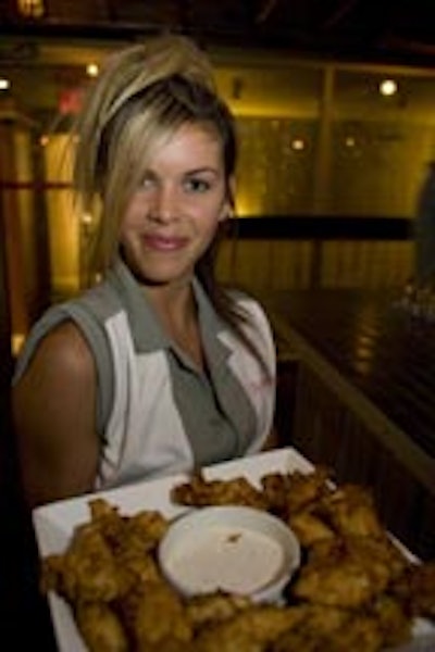 A caterwaiter from the Drake wearing era clothing served platters of fried food.