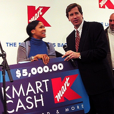 Charles 'Chuck' Conaway, chairman and CEO of Kmart, awarded 'Attention Kmart Shopper' announcement contest winner Tracy Baltimore a $5,000 Kmart gift card at the in-store event.