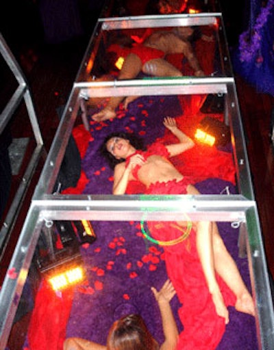 Models, draped in strategically placed red cloth, posed inside a plastic casing that created a living red carpet entrance.