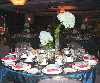 The centrepieces consisted of three fluted, clear-glass vases filled with beads, water, and greenery.