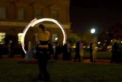 Two sequined performance artists from Cast of Thousands twirled flames on the lawn outside the National Building Museum as guests filed in on a red carpet.