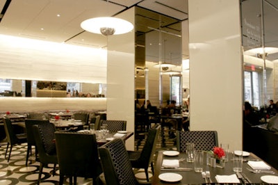 The cream-colored stone and mirrors in the main dining room contrast the darker tones of the furniture.