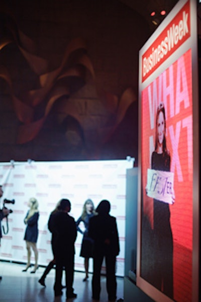 A large LED screen above the main stage showed images from the photo booth with the words 'What's Next' behind guests holding up flash cards.