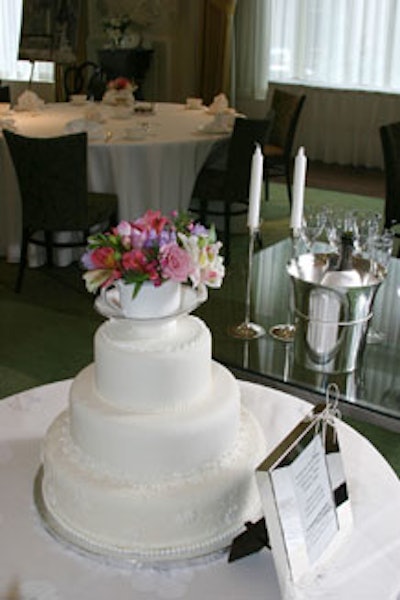 Vera Wang's new collections surrounded a white fondant cake topped with a flower-filled teacup.