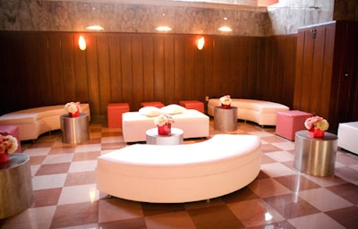 Room Service created a welcoming and fashionable sitting area with white couches and pink ottomans.