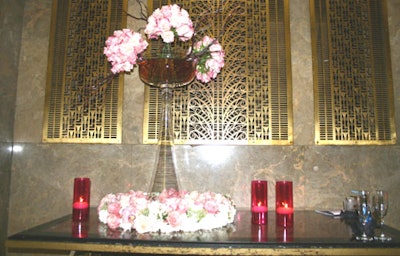 Parrish Designs created dramatic arrangements of pink and white roses with pillar candles.