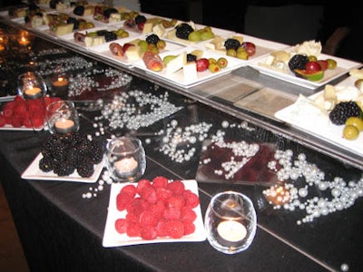 Food stands featured Italian foods by Davids. Berries, cheese, and olives were served on a silk-blend draped stand with pearl accents and candlelight.