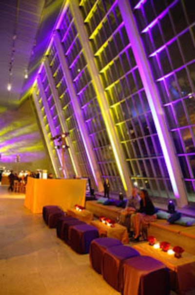The colors of the fabrics used in the seating and table covers matched the purple, blue, and gold lighting.