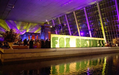 A large topiary across the still pool spelled out 'Fox Business.'