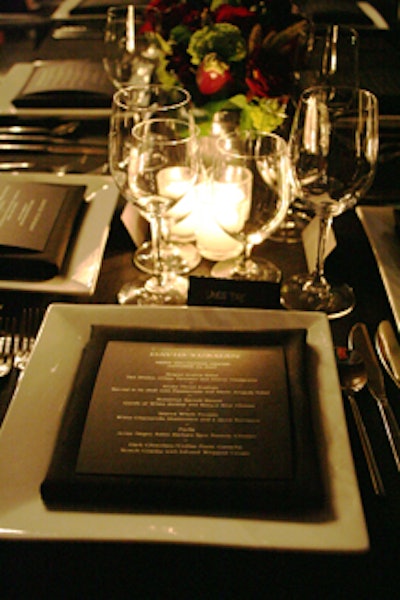 Simple banquet tabletops featured square plates and dark roses.