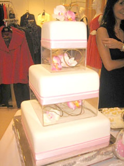 Todo Dulce/Everything Sweet constructed a three-tier pink and white cake, with each layer separated by clear plastic boxes filled with pink and white orchids.