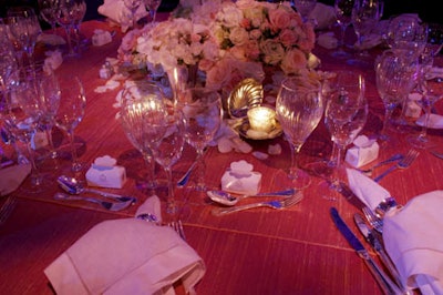 Arrangements of pastel-colored roses and silver accents topped tables.