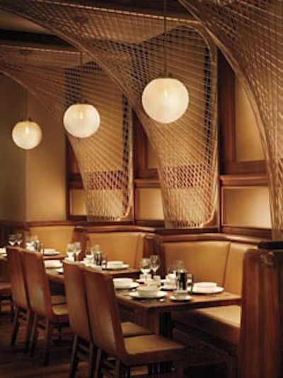 The restaurant has woven arches, teak dining tables, and cream-colored leather banquettes.