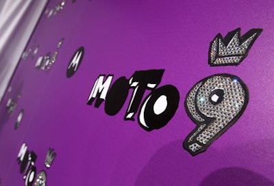 Moto 9 logos encrusted with Swarovski crystals decorated a purple press wall.