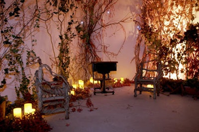 A secret garden room housed grape vines, small chairs, and candles.