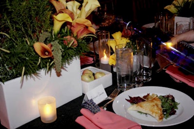 Floral arrangements of herbs and flowers such as calla lillies topped tables.