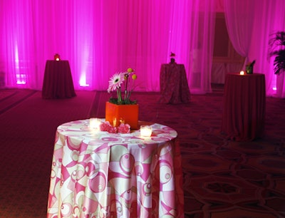 Standing tables swathed in pink and topped with potted gerbera daisies and white votives accented the after-party decor.