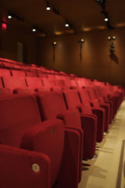 Filled with vibrant red seats, the auditorium is an appropriate space for lectures, screenings, and performances.