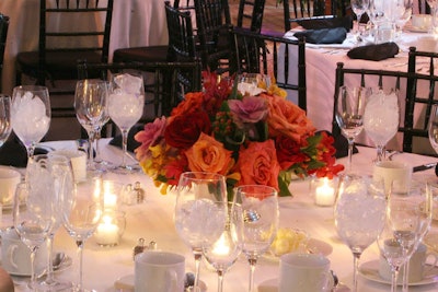 Jack Lucky combined deep red, burnt orange, and rich peach roses with purple cabbage and winterberries for the table centerpieces.