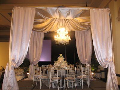 Suspended from the peak of the custom silk canopy was a magnificent chandelier constructed and accented with flowers in shades of pink and cream.