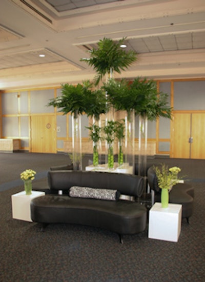 Green florals and vases accented the black-and-white palette of the reception area seating arrangement.