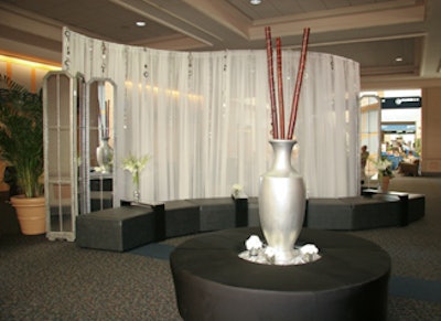 An S-curve of ottomans and sheer white draping adorned with chains of geometric silver circles separated the MPI event from others at the convention center.