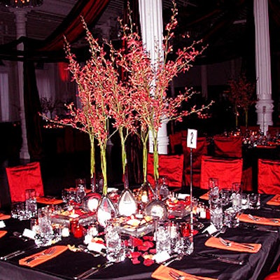 The tables were covered with red and black silk shantung tablecloths, with centerpieces of tall, thin vases full of bright pink orchids towering above shallow glass trays filled with water, candles and flowers.