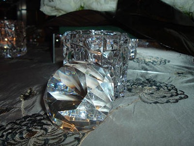 Cut-crystal candleholders and large faux diamonds were used as table decor at Tiffany & Company.