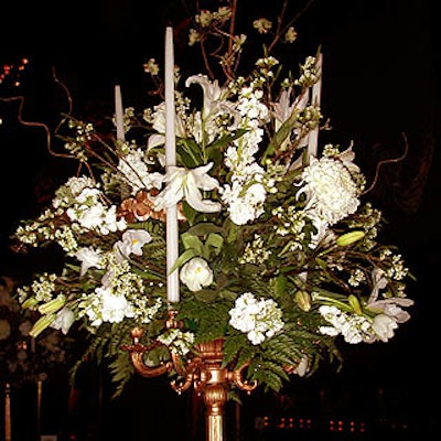 Victor's Garden District's beautiful white and gold centerpieces included lisianthus, Casablanca lilies, chrysanthemums, white tulips, wax flowers and stock, with four white taper candles surrounding each setting.