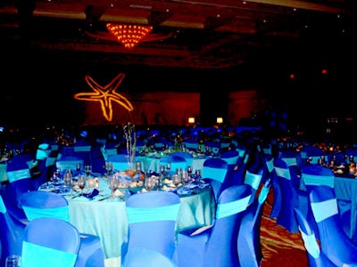 Over the Top Rental Party Linens, A Basket Affair, and PSAV created an underwater paradise for the night with ocean blue linens, living centerpieces, and sea-creature projections on the walls.