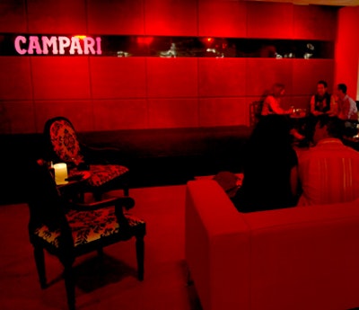 Attendees relaxed in the Campari-red lounge located within the exhibit space.