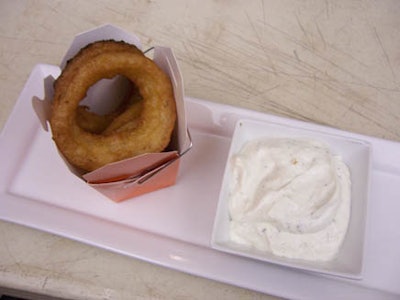 Onion rings were served in bright-orange takeout containers alongside a creamy onion dip.