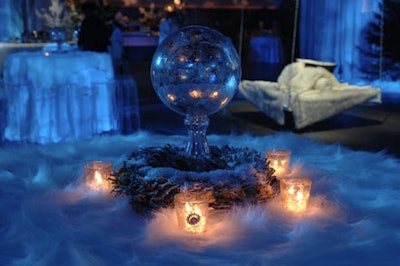 Glass spheres placed inside small wreaths and surrounded by votive candles topped tables throughout the ice castle room.