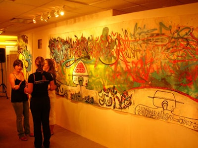Large graffiti paintings on white canvas covered the walls of the Dacra Development building.