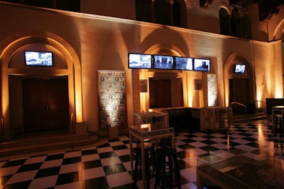 Flat-screen monitors meant to evoke surveillance equipment showed black-and-white images of the party space.