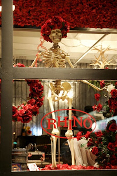 A rose-covered skeleton stands in a front window display.