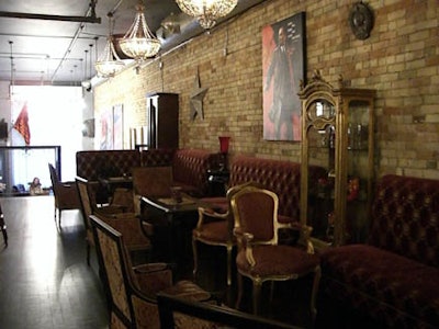 A lounge area on the second floor comprises banquette seating and ornate red and gold chairs.