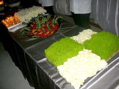 Candles, white roses, and small patches of pristine grass adorned the buffet tables.