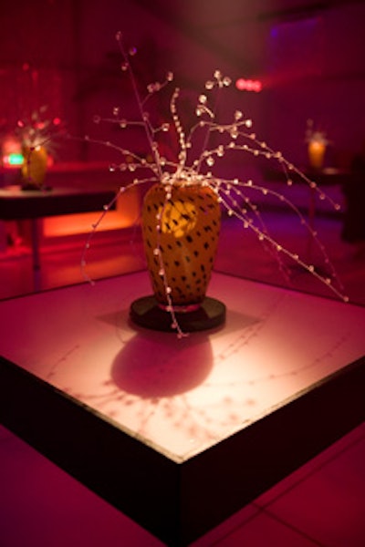 Crystal beaded branches set into leopard-like vases topped stand-up cocktail tables.