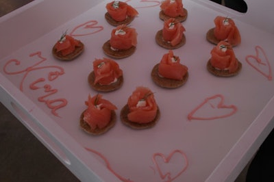 On a tray piped with pink hearts, Entertaining Ideas Catering served smoked salmon and dill on buckwheat blinis.