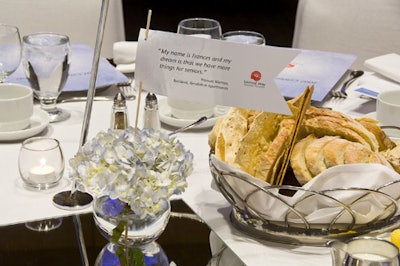 Small floral arrangements featuring hydrangeas and a quote about dreaming topped each table.